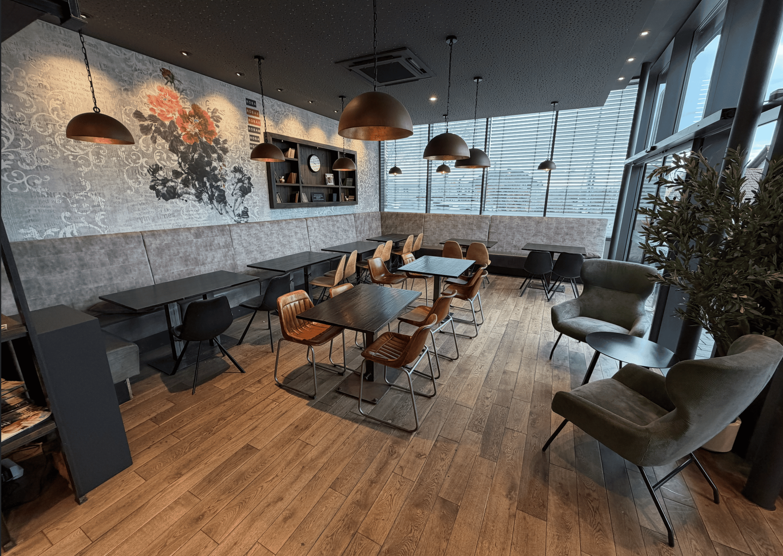 Sitzbereich unseres Cafés mit Tischen, Sitzbank und Sesseln in Kressbronn